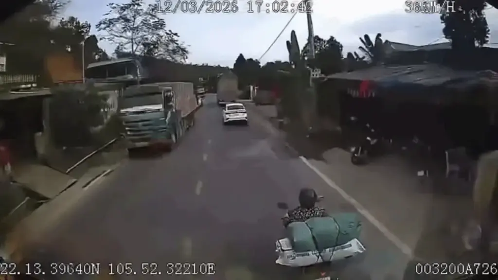 Xe máy biến mất trước đầu xe tải trong vài giây